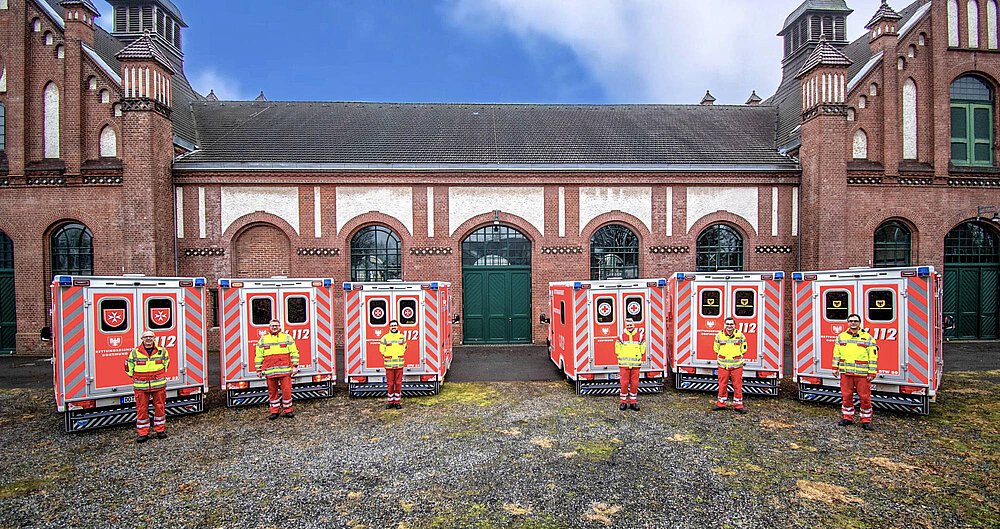 Sechs neue Rettungswagen für den Rettungsdienst. Im Hintergrund die Reche Zollern